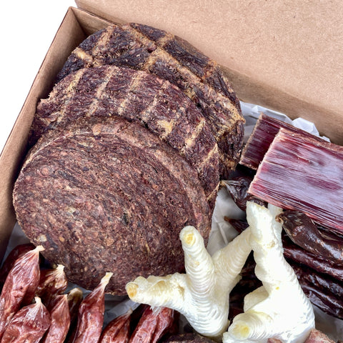 Overhead shot highlighting mini burgers and quarter pounder natural dog treats from the Butcher’s Banquet box.