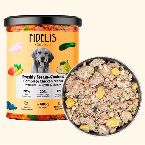 Fidelis Freshly Steam-Cooked Chicken Dog Food 400g tub beside a bowl of chunky chicken with rice, courgette and mango