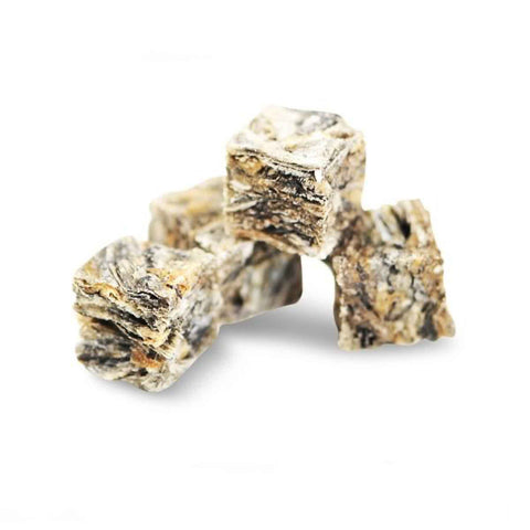 Three pieces of dried fish cube treats for dogs on a white background