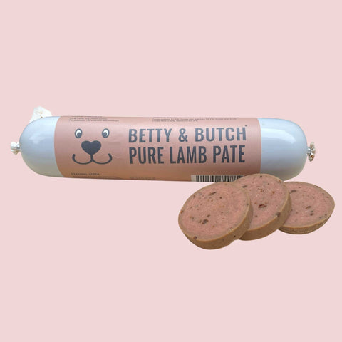 Roll of Betty & Butch Pure Lamb Pate with slices on a pink background