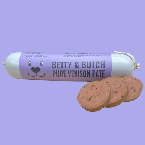 Roll of Betty & Butch Pure Venison Pate with three slices on a purple background